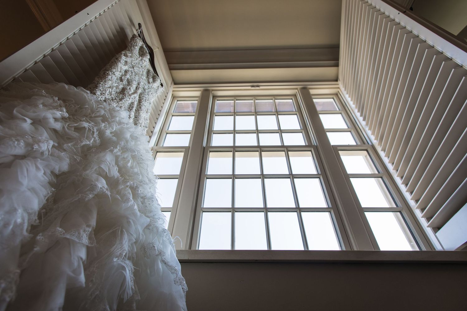 Architectural detail of tall windows with white trim and natural light streaming in.
