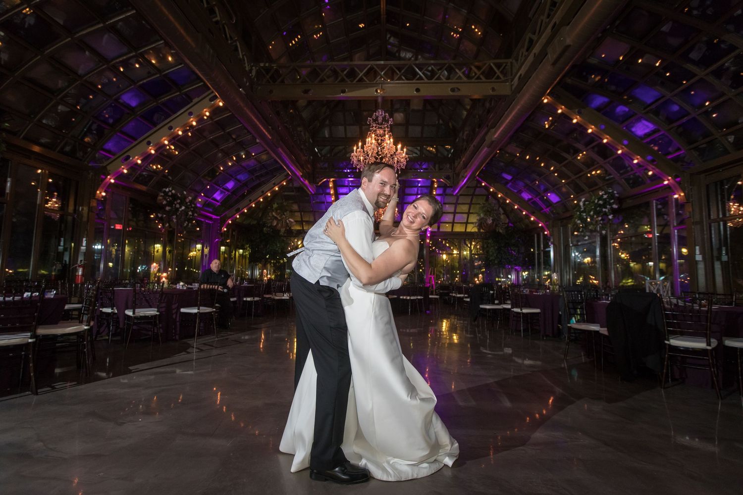 Romantic first dance under dramatic purple lighting at wedding reception.