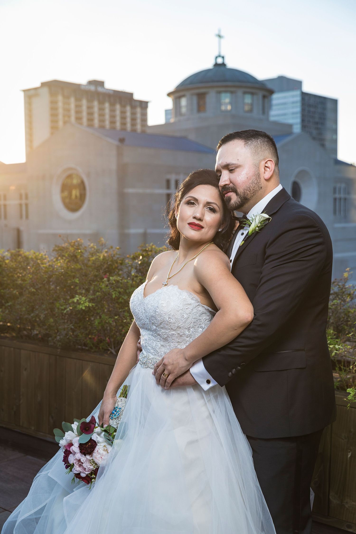 Elegant wedding portrait with city buildings and architecture in background.