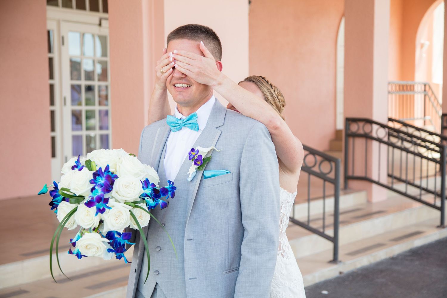 Wedding party members in light blue and white attire posing outdoors.