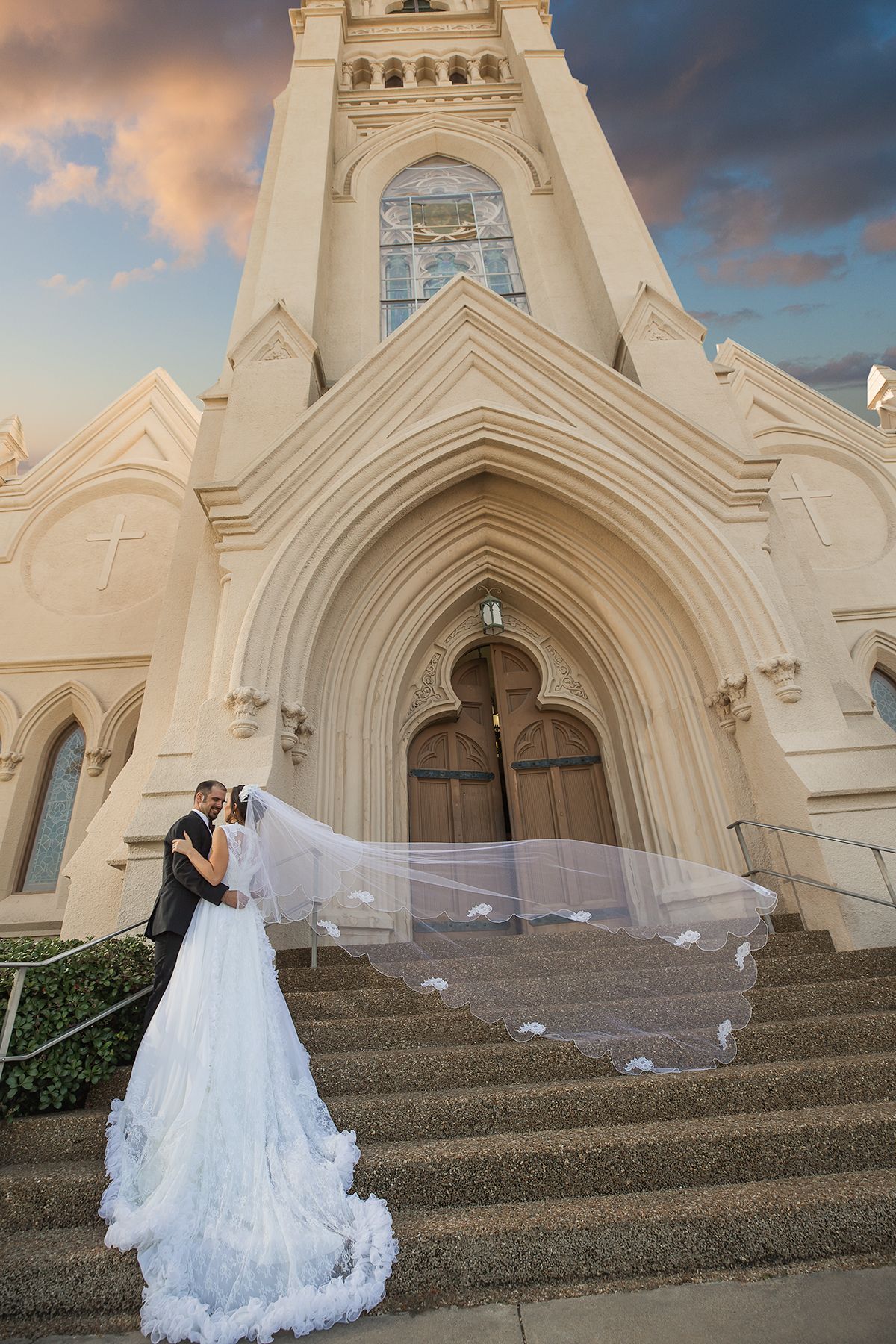 Beautiful cathedral steps with flowing white wedding dress and veil creating dramatic scene.