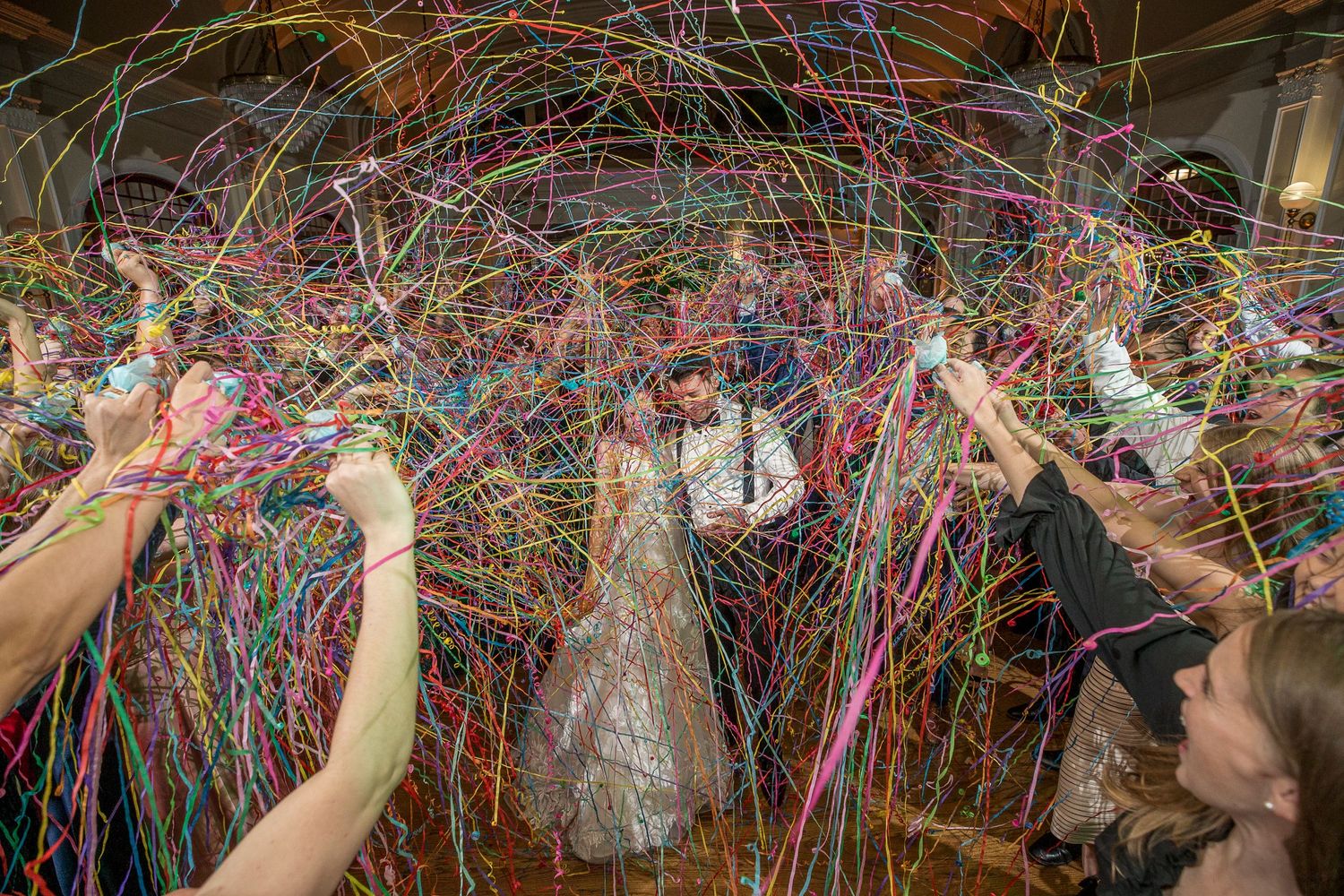 Colorful streamers create a festive pattern against a dark background at a celebration.