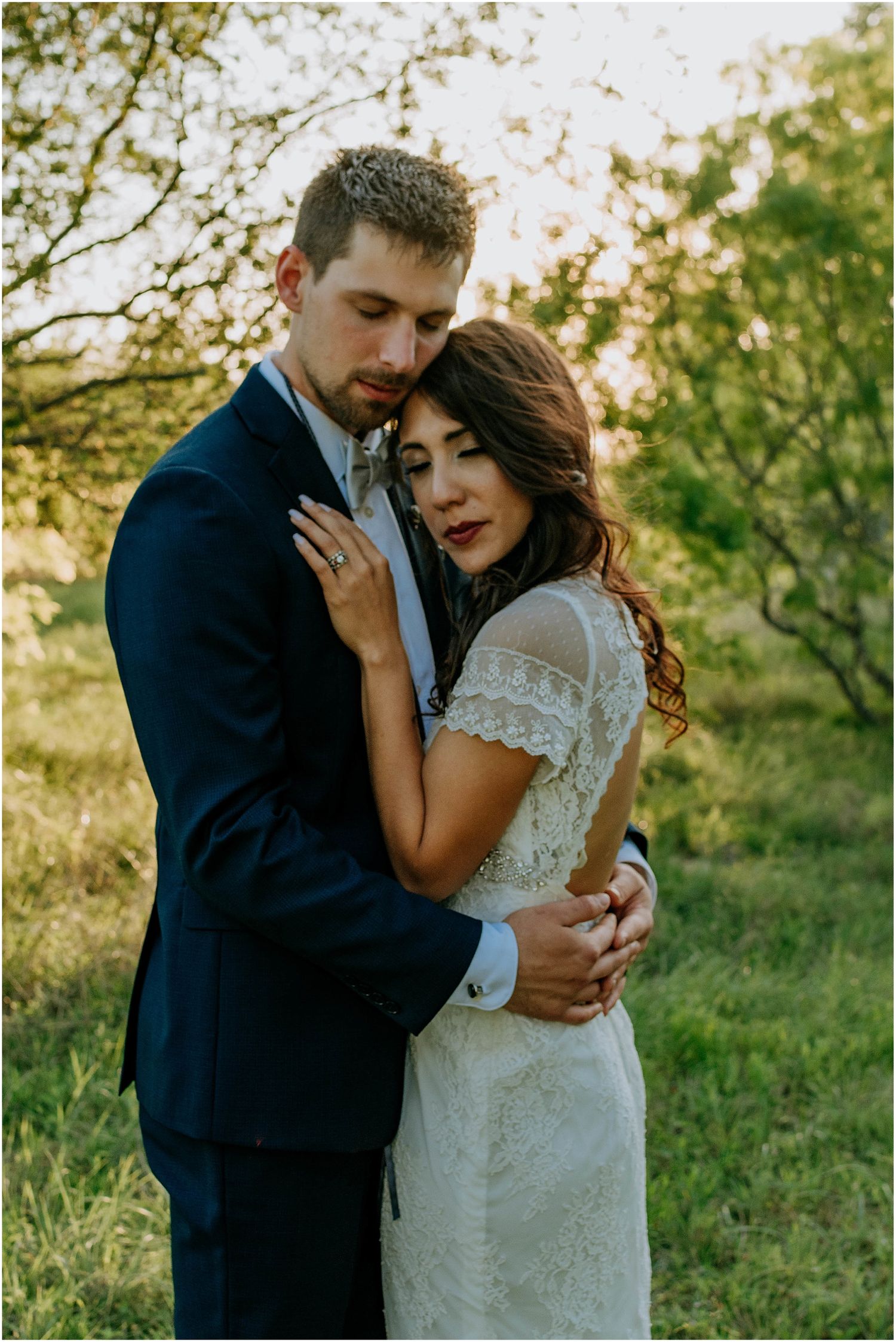 Romantic outdoor wedding portrait with natural sunlit background and elegant attire.