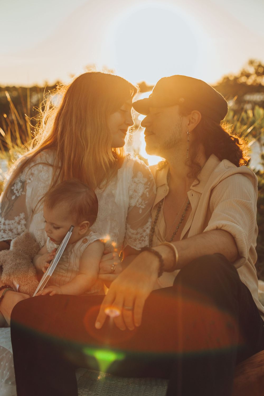 Intimate family moment captured during golden hour by a lakeside.