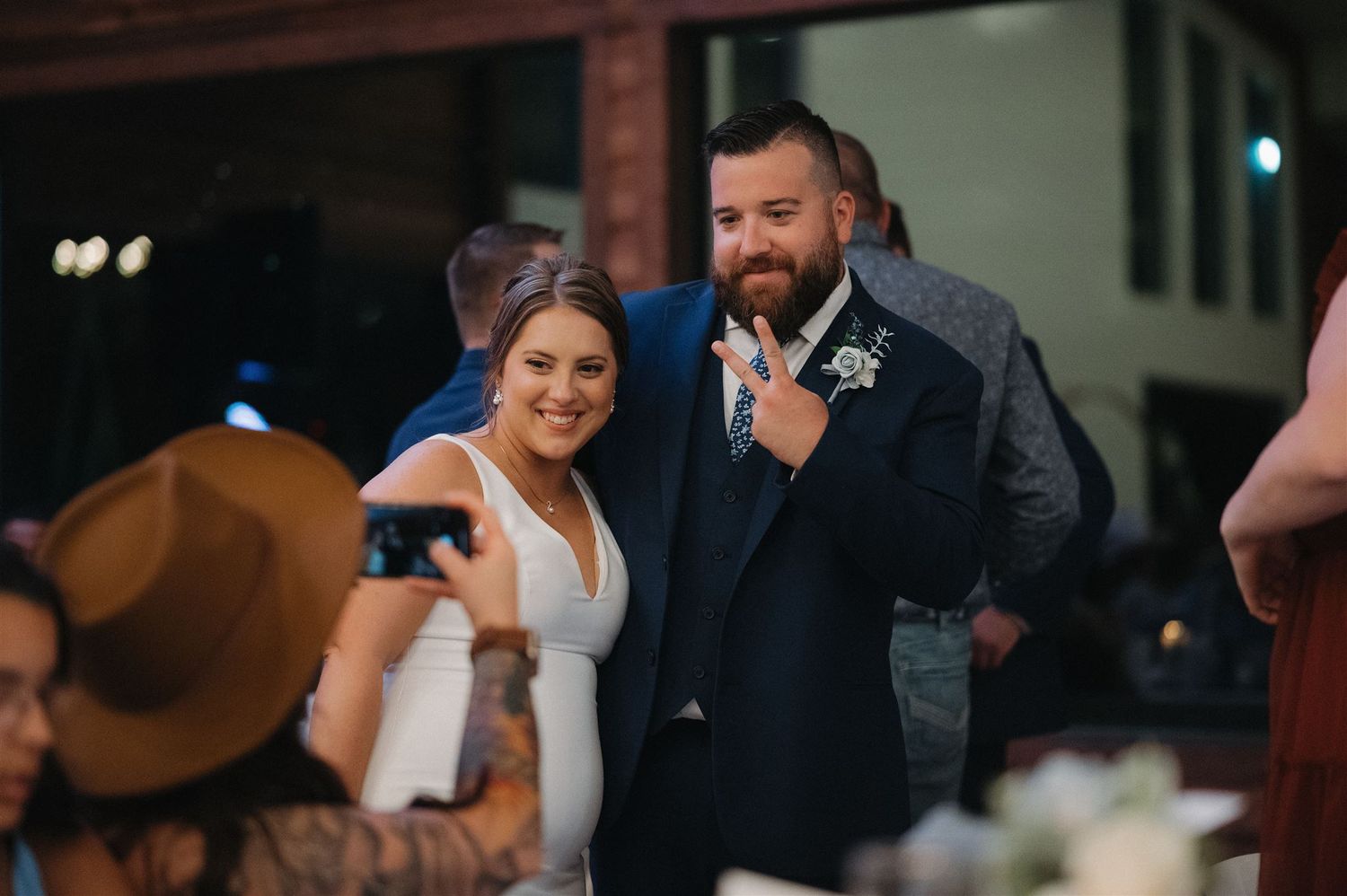 A wedding celebration moment with the couple and guests seated at decorated tables.