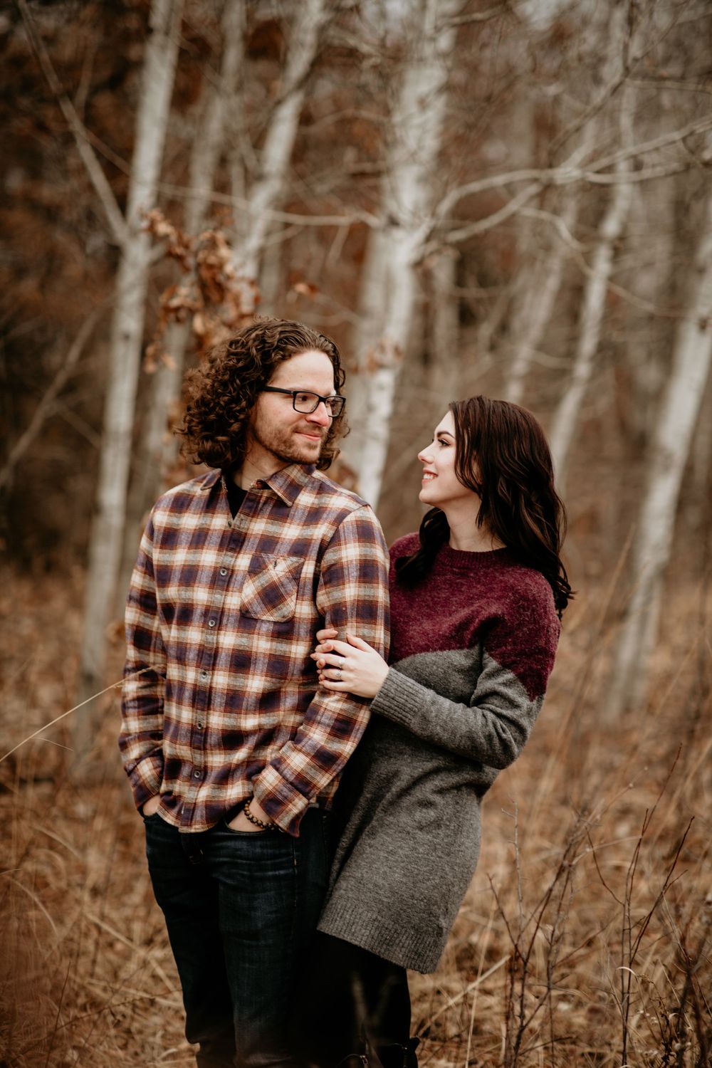 Couple gazing at each other lovingly in an autumn birch tree forest.