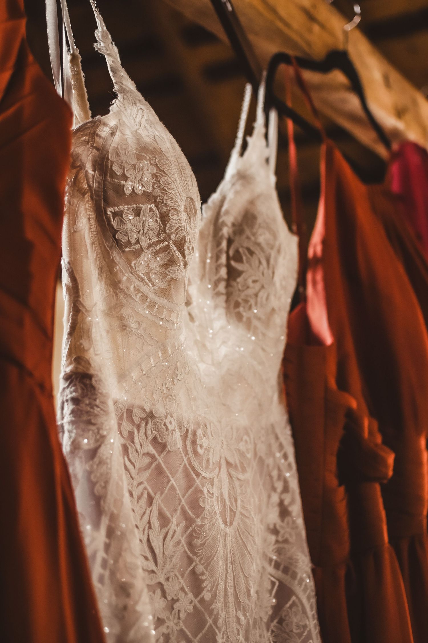 Close-up detail of white lace wedding dress bodice showing intricate floral patterns.