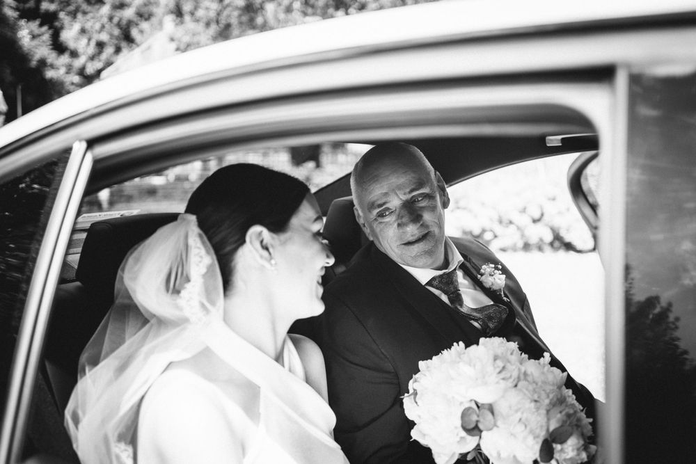 Black and white photo capturing a candid moment inside a wedding car.
