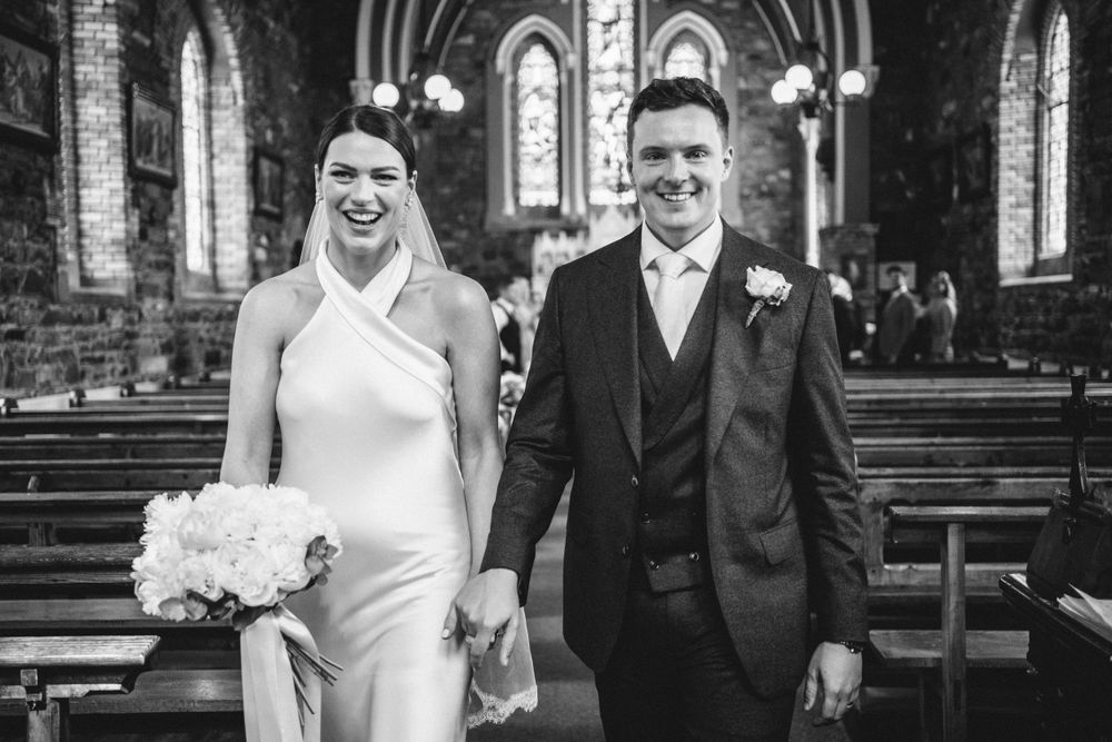 A joyful moment in a classic church with arched windows and wooden pews.
