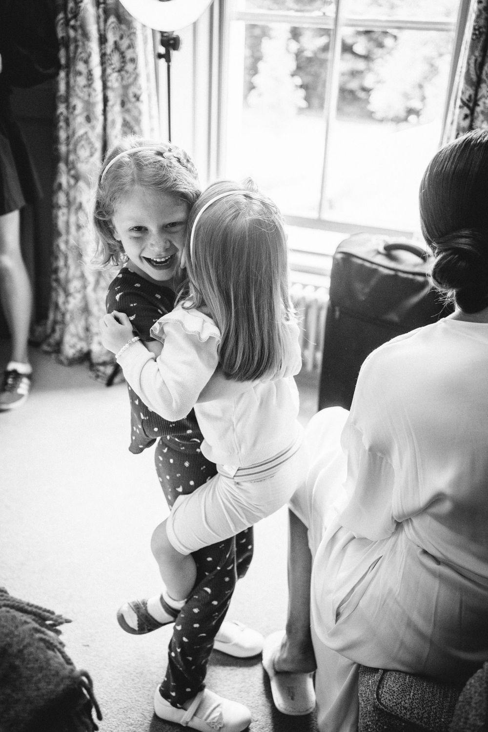 Two children playing and hugging during a joyful moment in black and white photography.