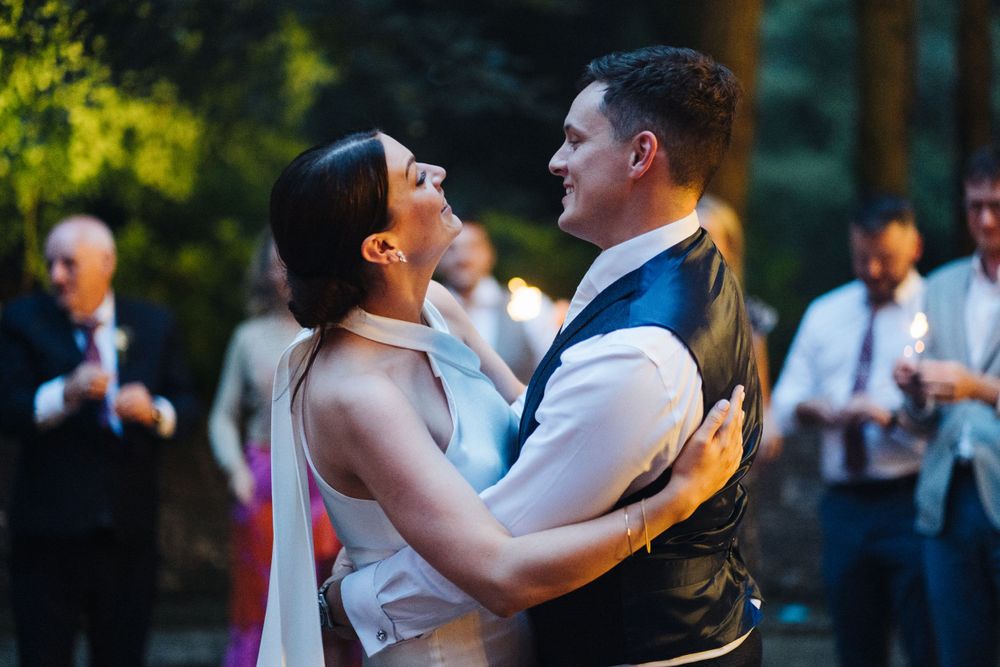 Couple shares an intimate dance moment during outdoor wedding reception.