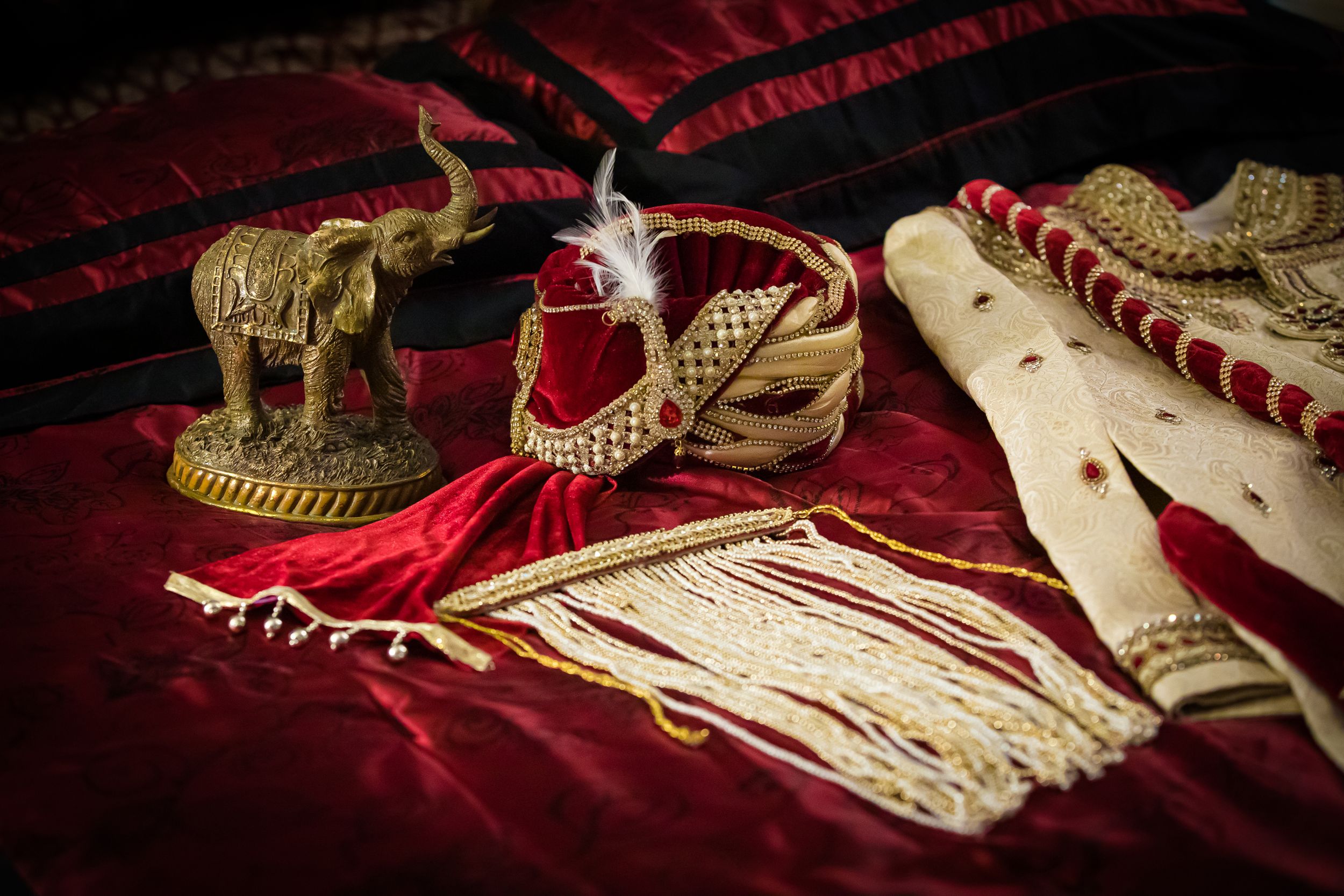 Wedding accessories and decorative items arranged on red velvet background.