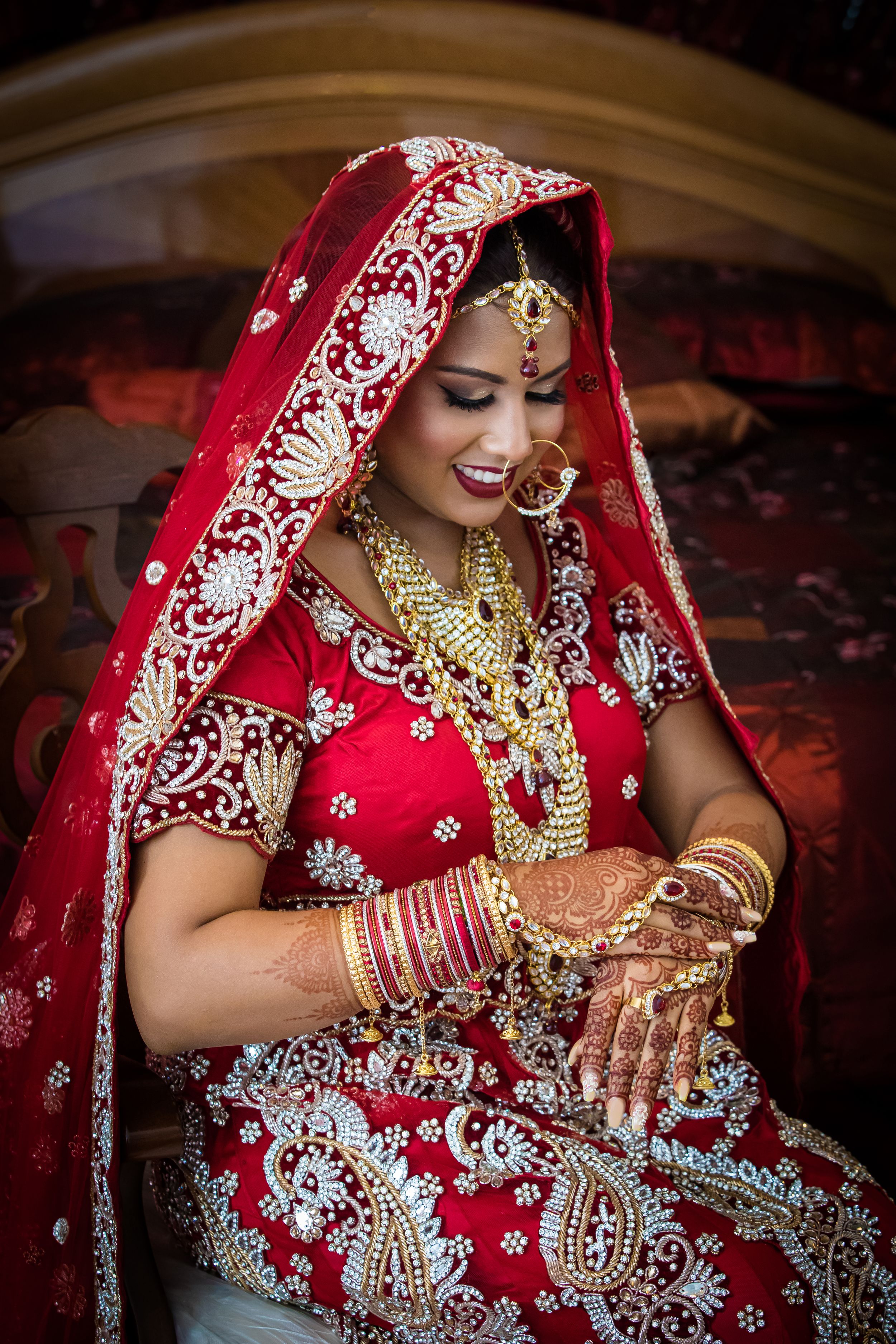 Ornate bridal attire featuring intricate embroidery and traditional Indian wedding jewelry.