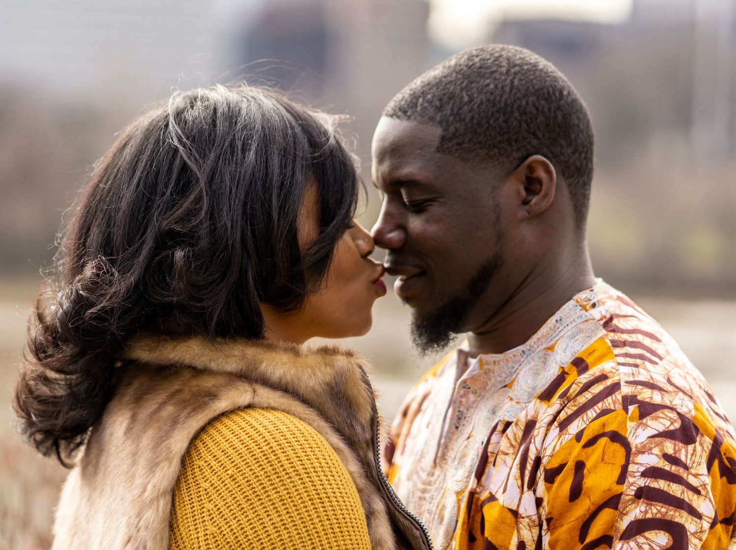 An intimate moment between a couple in coordinated yellow and patterned outfits.