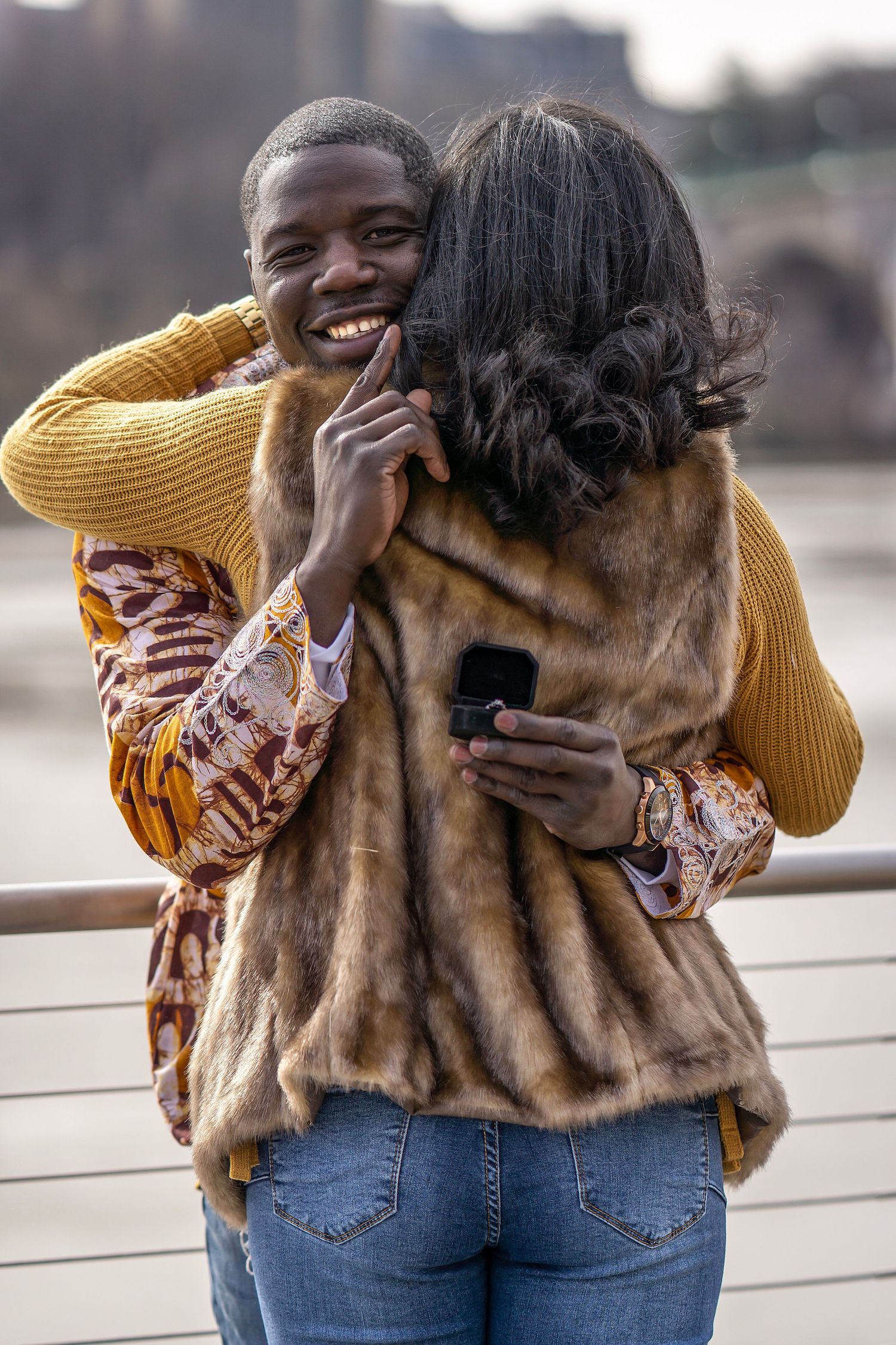 A joyful moment captured between a couple embracing and laughing together outdoors.