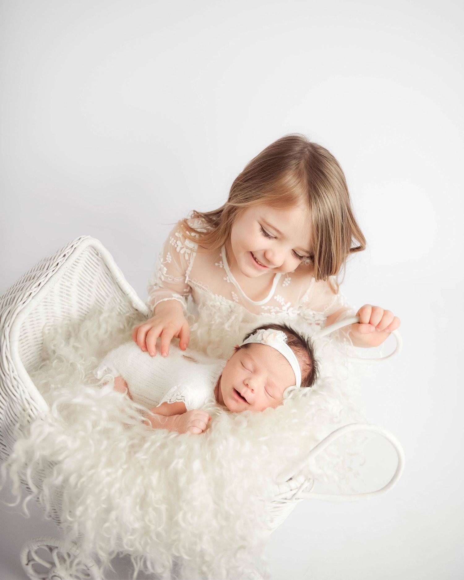 sister looking over newborn baby sister