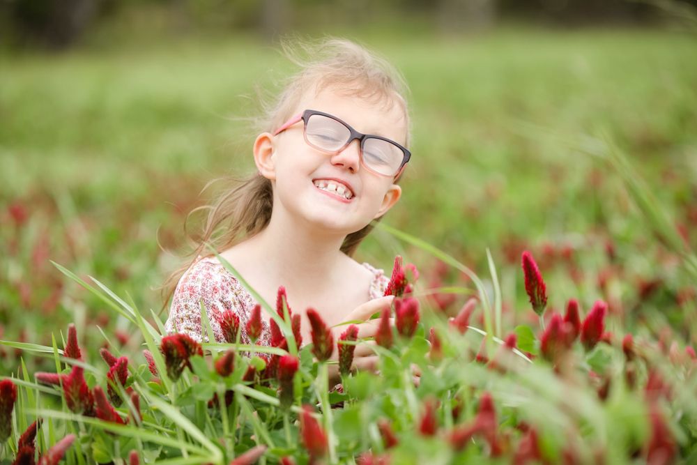 child being silly in crimson clover field at ward's farm in salem new jersey