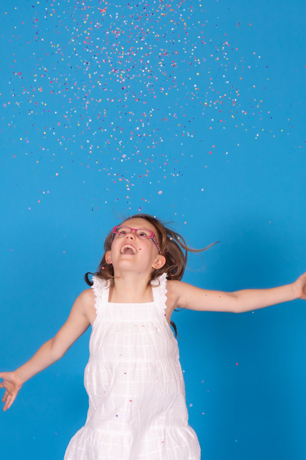 child throwing confetti on blue jay savage paper backdrop in studio in clayton new jersey Gloucester