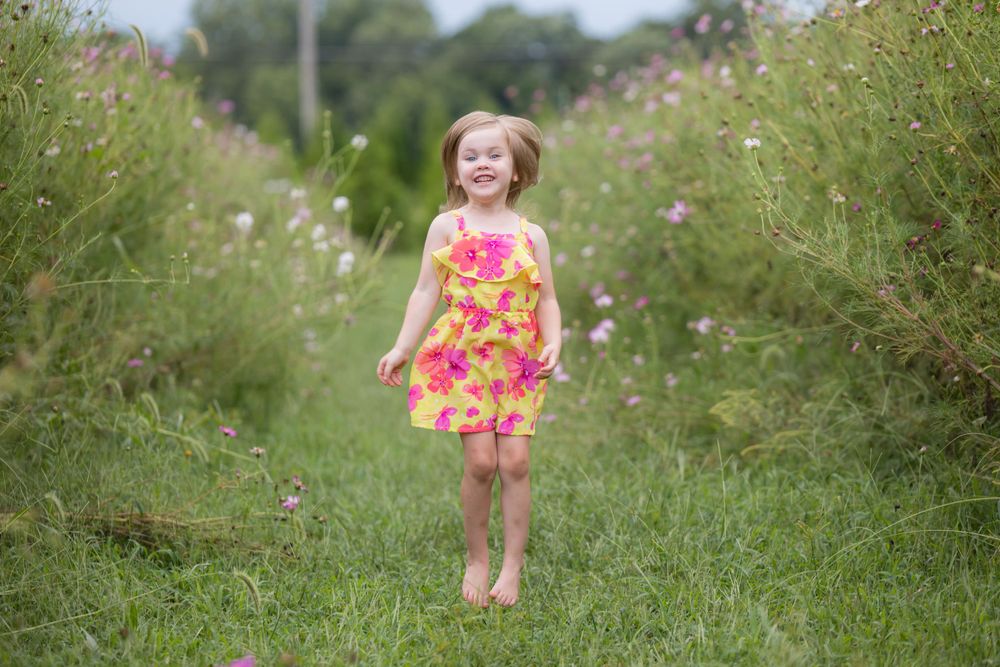 child jumping in zinnia field at ward's farm in salem new jersey