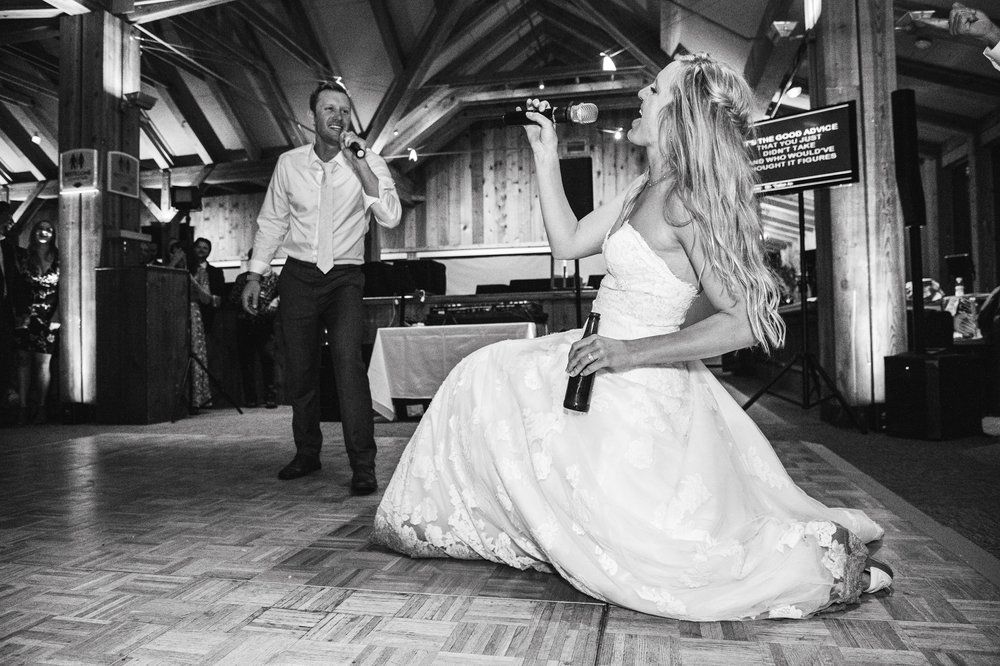 Black and white photo of wedding couple dancing in an elegantly lit reception venue.