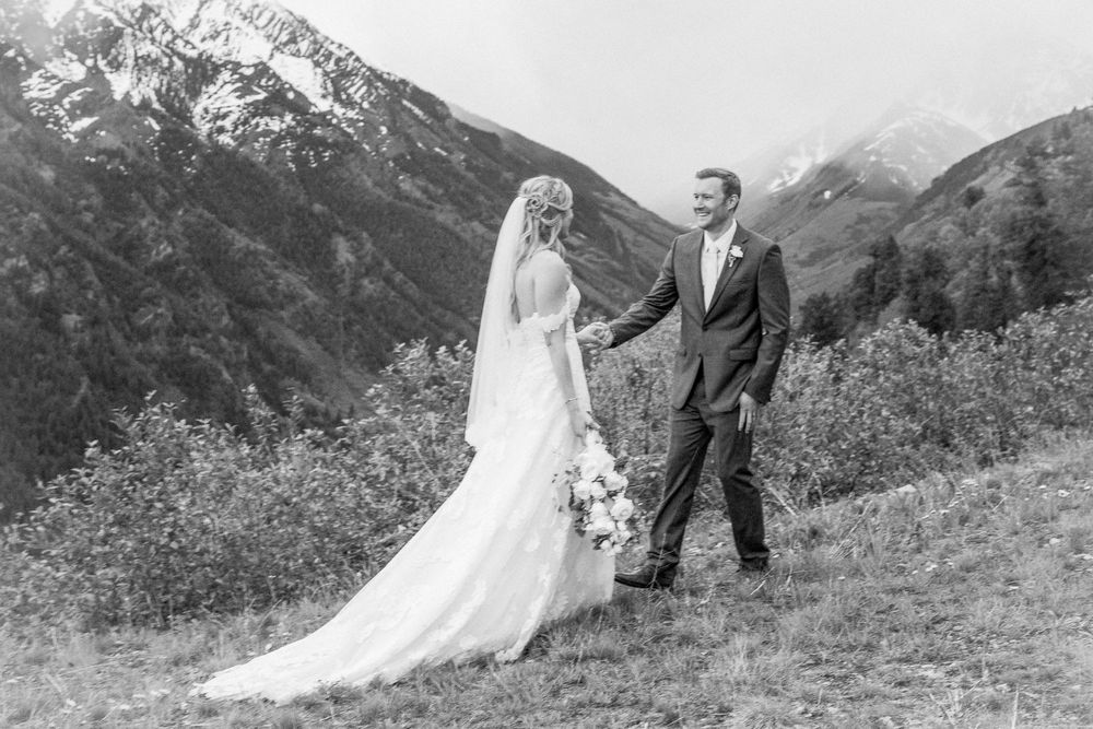 Black and white wedding photo with mountain landscape behind the couple.