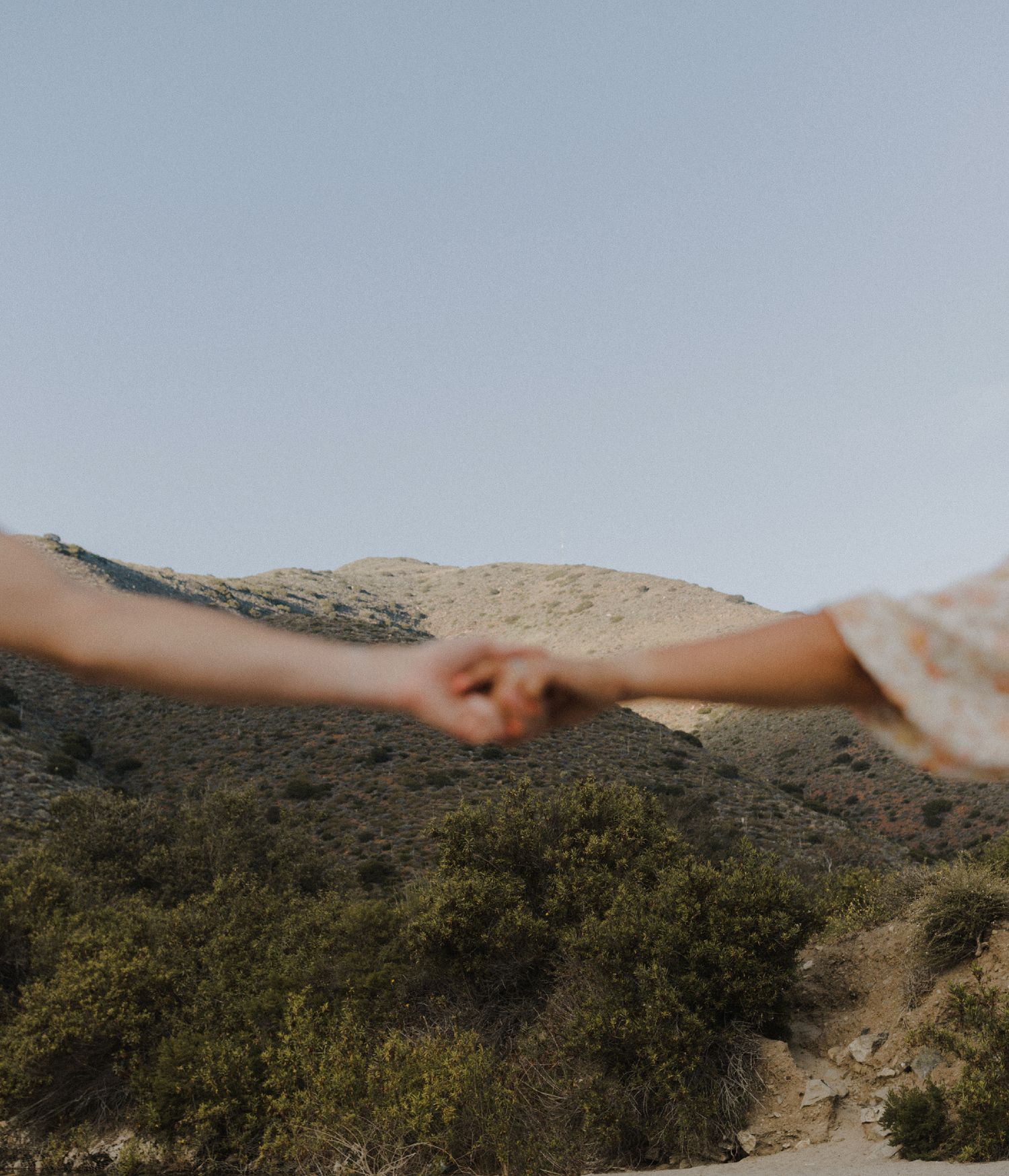 E. Noelle Photography couple engagement in the Los Angeles Malibu hills, holding hands in front of mountain landscape
