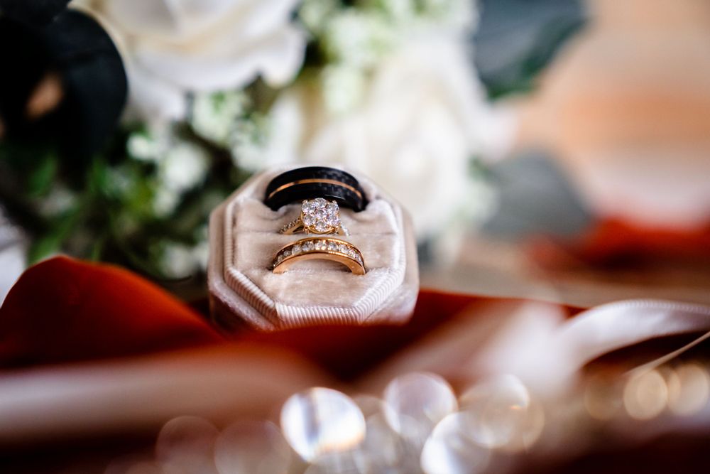 Wedding reception table details with glassware and soft bokeh lighting effects.