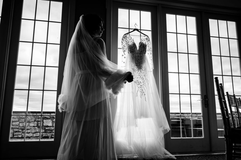Artistic silhouette of wedding dress through large window panes.