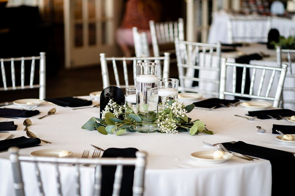 Elegant wedding reception tables set with white linens and floral centerpieces.