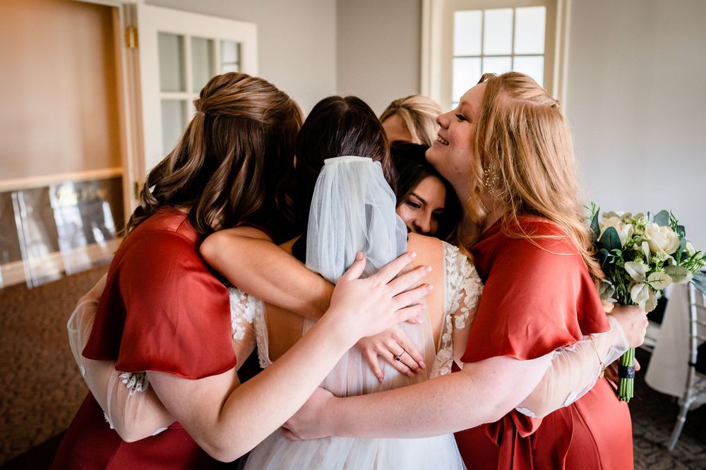 Wedding party members share embraces and emotional moments before the ceremony.