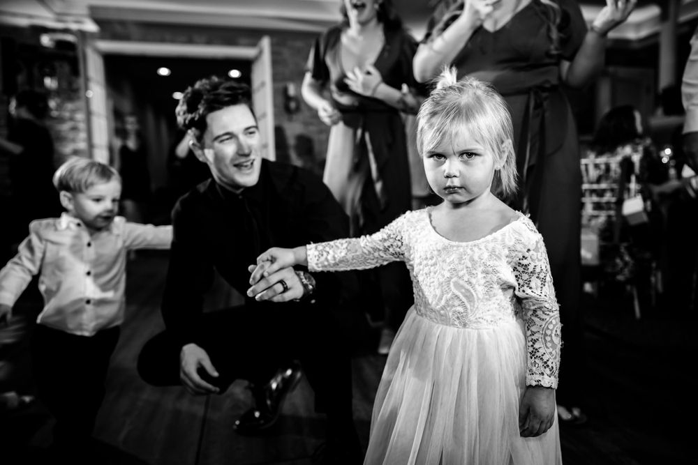 Black and white photo of joyful wedding celebration with guests and children.