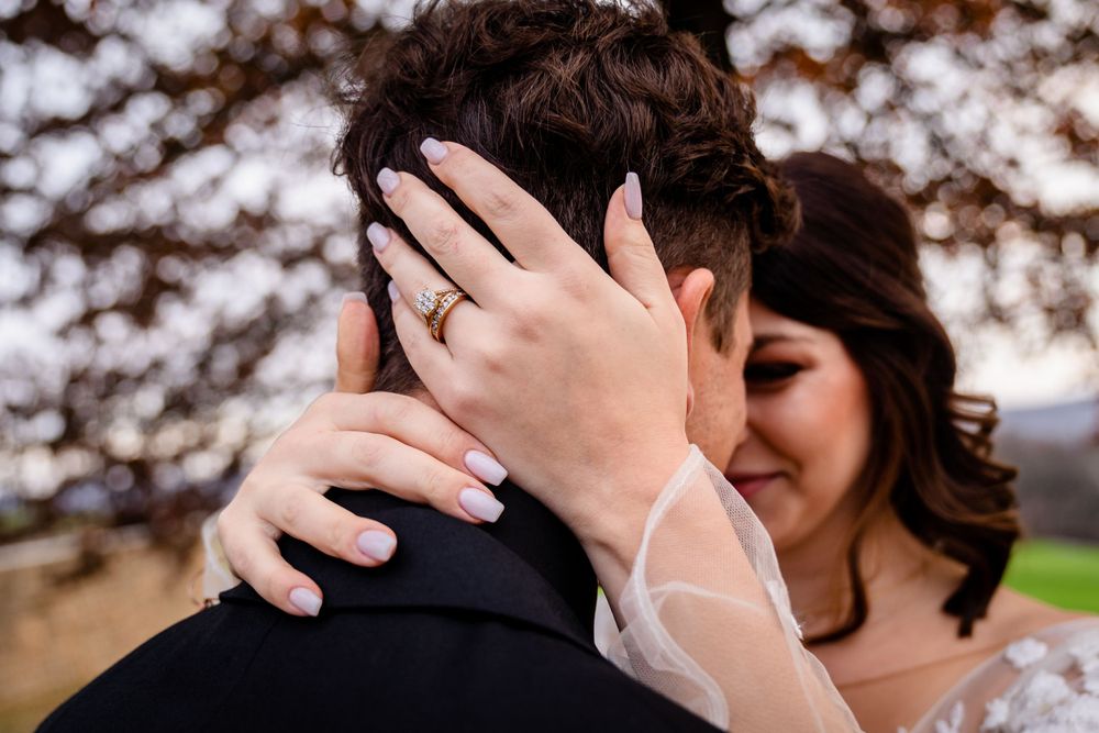 Intimate wedding couple portrait with autumn trees in soft focus background.