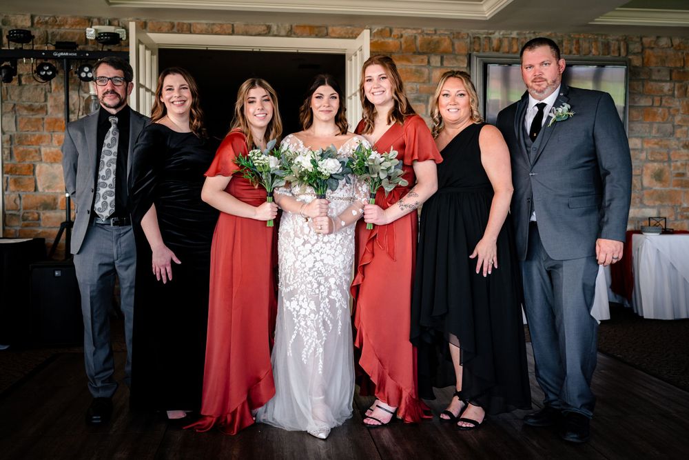 Wedding party group photo in formal attire with red bridesmaid dresses.
