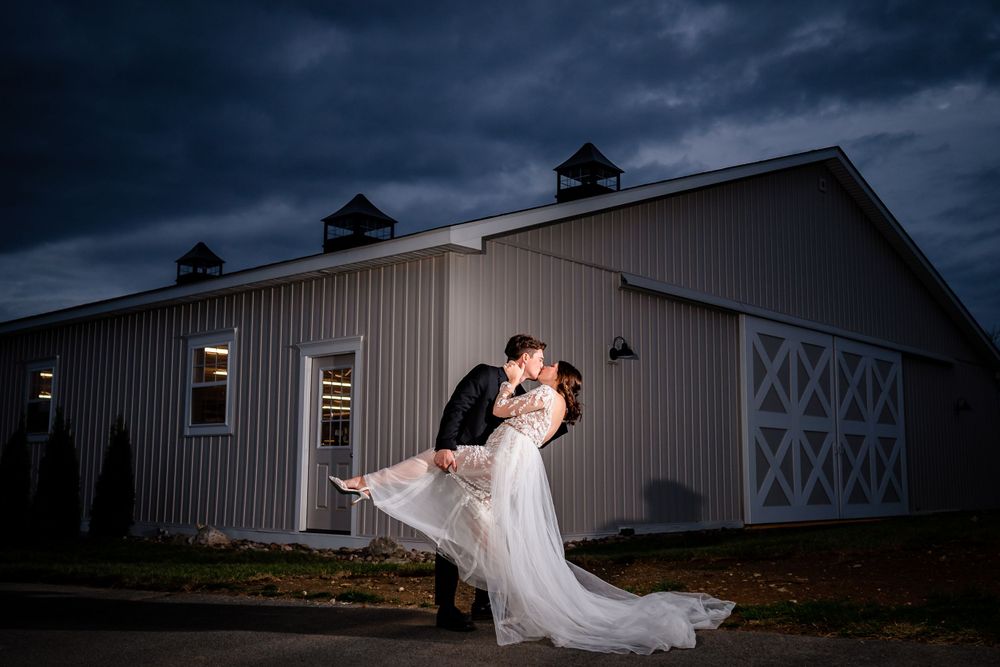 Artistic wedding photos captured outside a rustic barn under moody storm clouds.