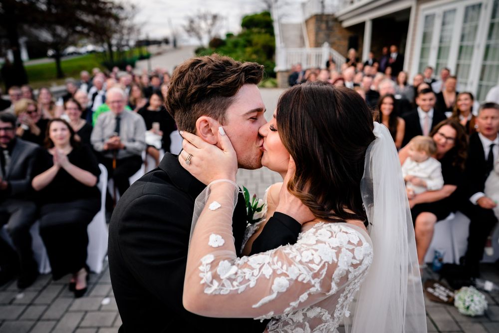 Wedding celebration on an outdoor patio with guests clapping during reception festivities.