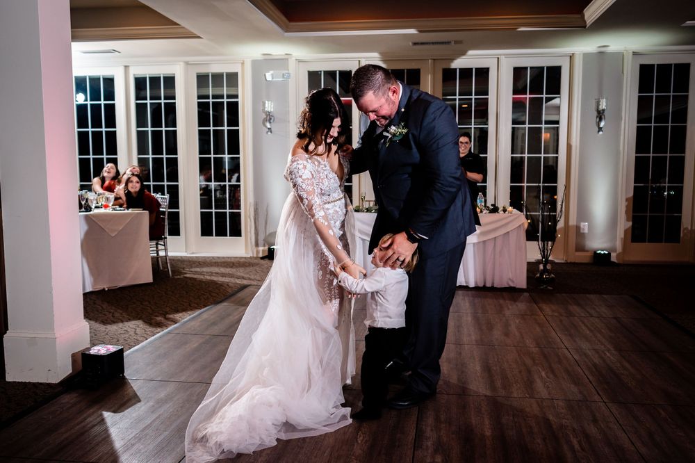 Elegant wedding reception venue with couples dancing on a hardwood floor.