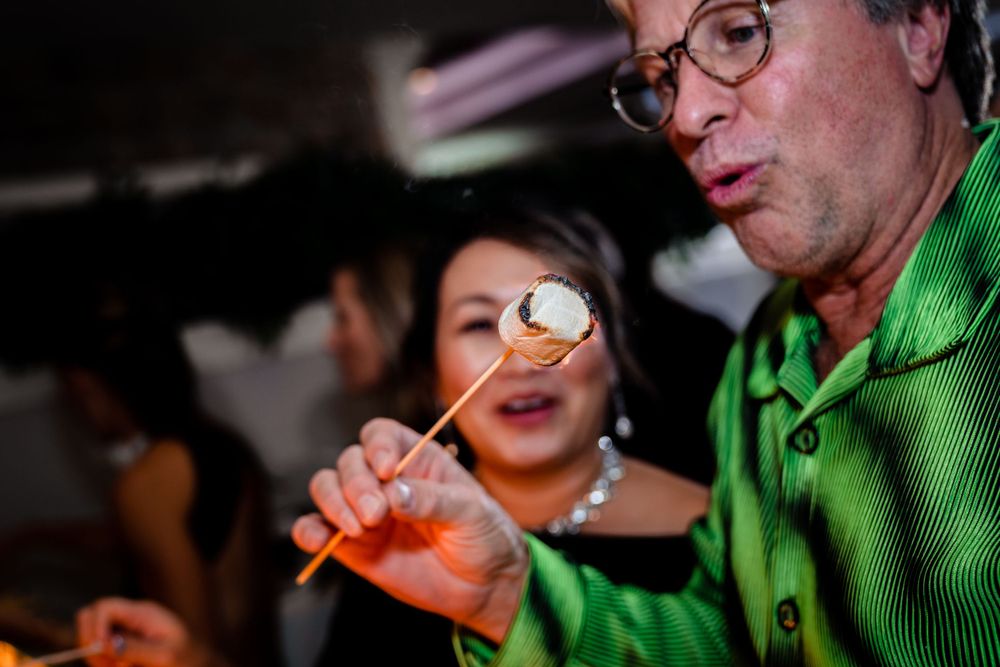 Candid moments of guests enjoying themselves at a dimly lit reception.