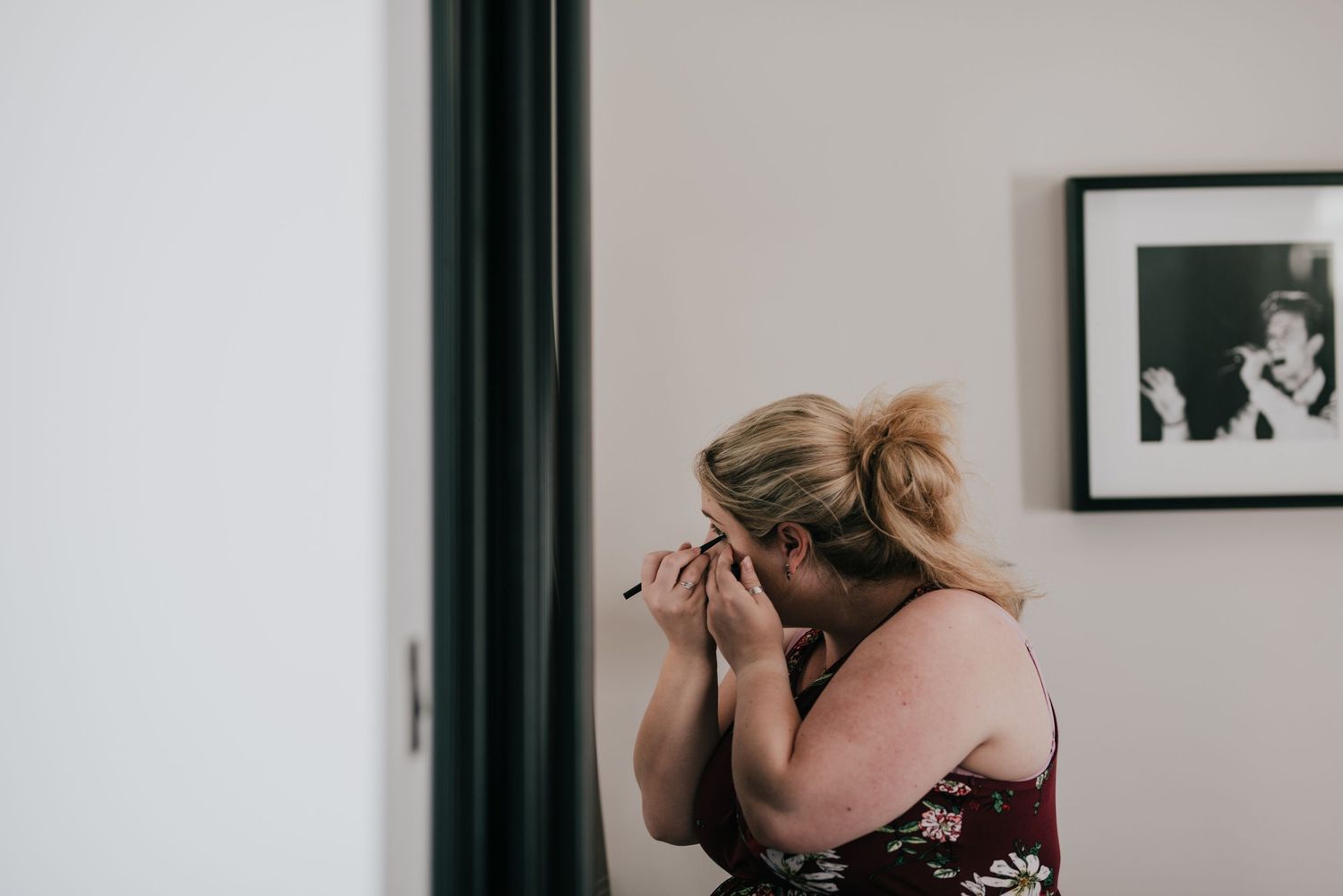 Emotional candid moment captured as someone covers their face during wedding preparations.