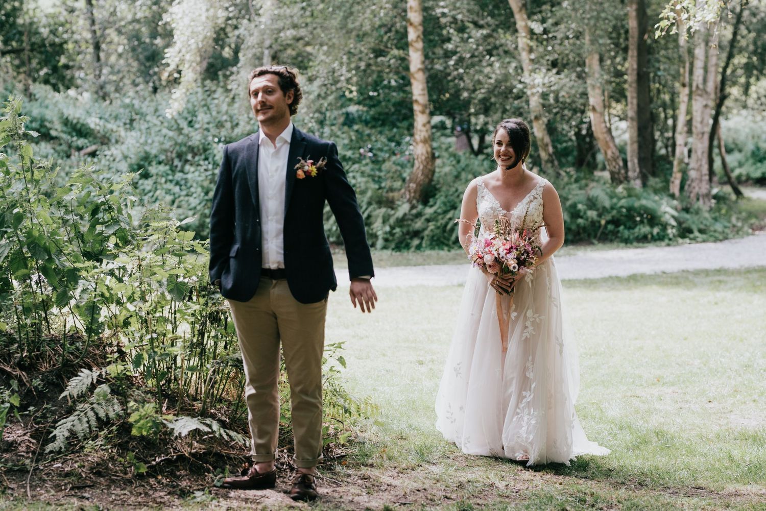 A couple walking together during their forest wedding ceremony.