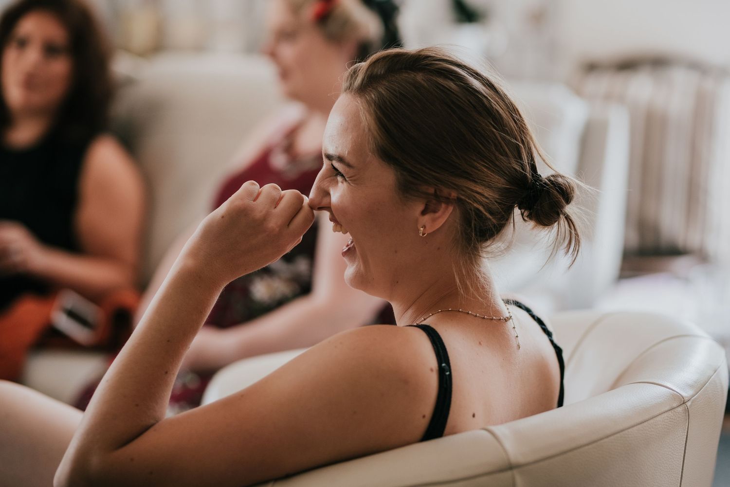 A relaxed moment captured during wedding day preparations in a bright indoor setting.