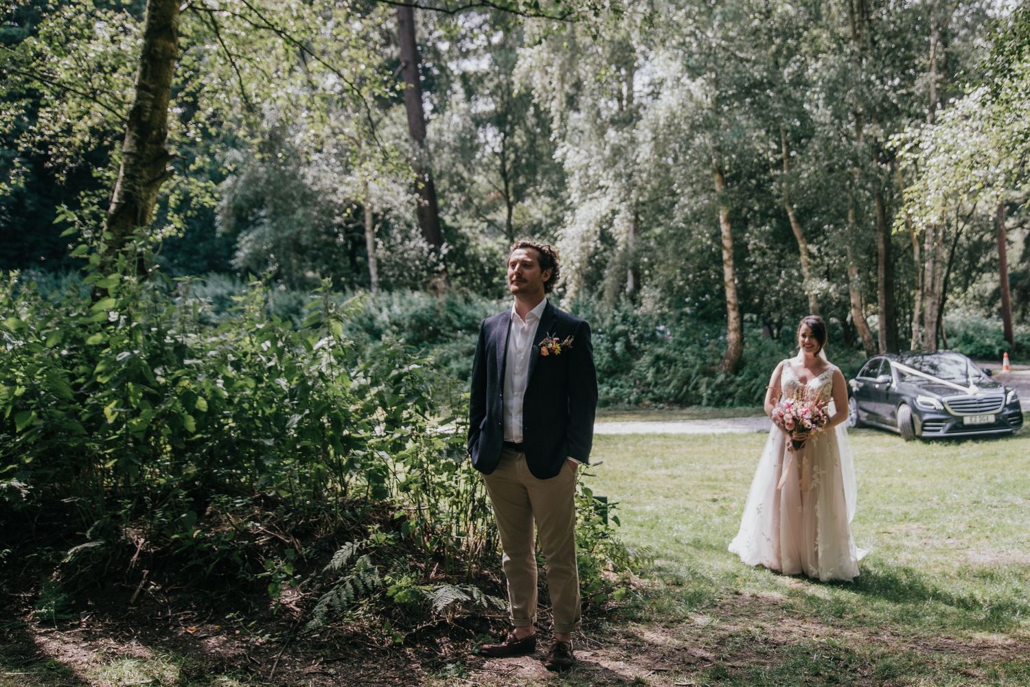 Couple having their first look moment in a sunlit garden setting.