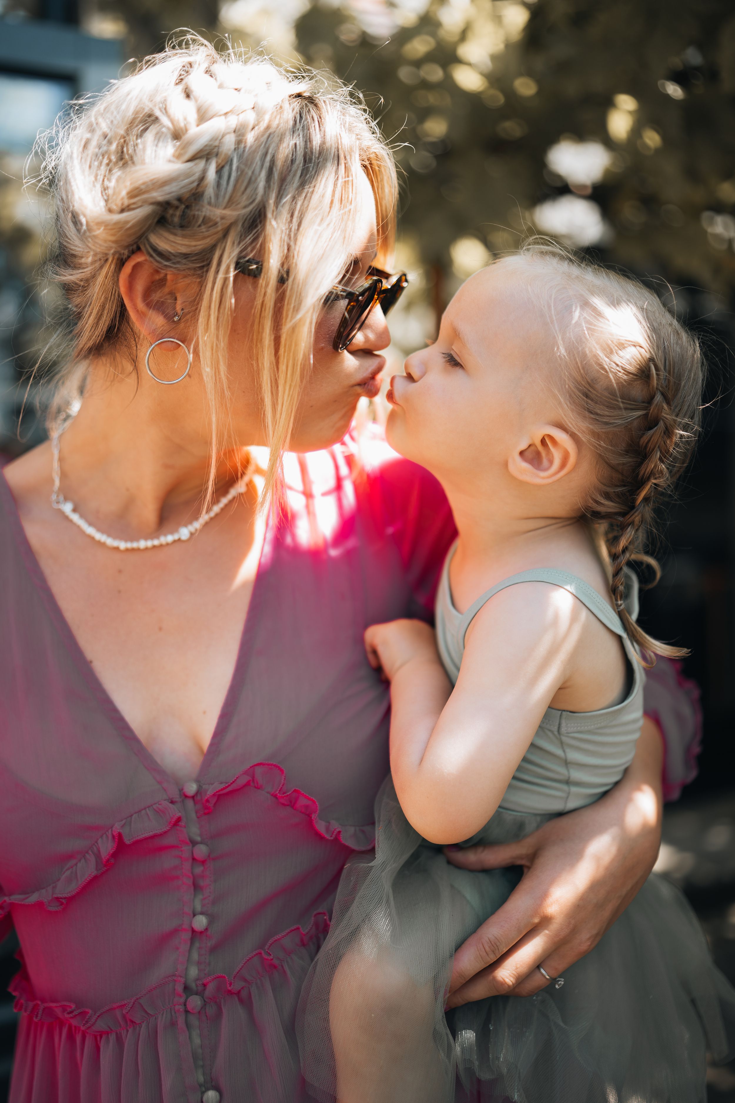 Tender moment between parent and child in summer garden setting.