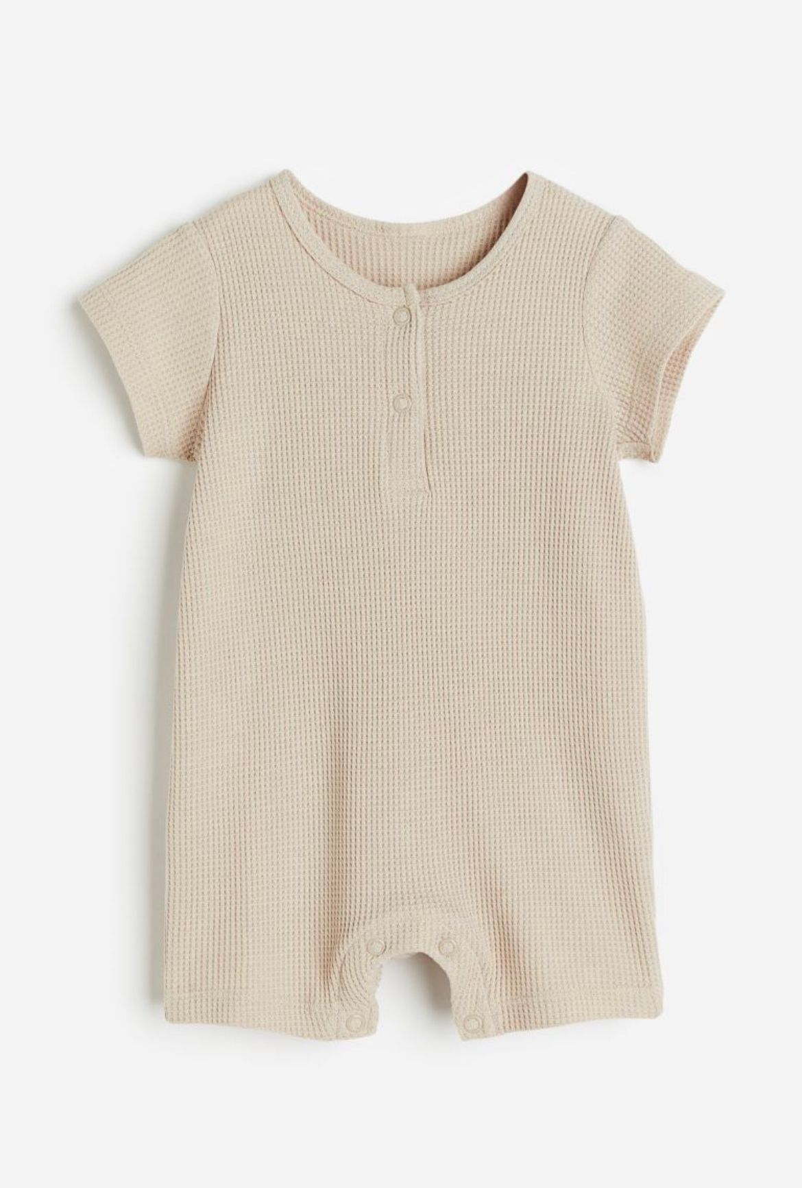 Neutralt farvet strikket babyromper med korte ærmer og knaplukning foran.