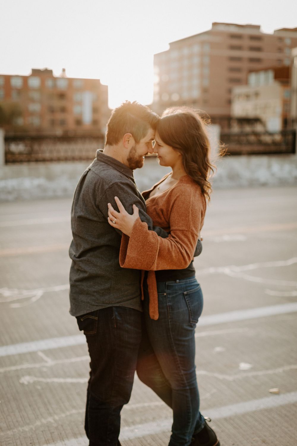 Intimate sunset moment between couple in urban parking lot.