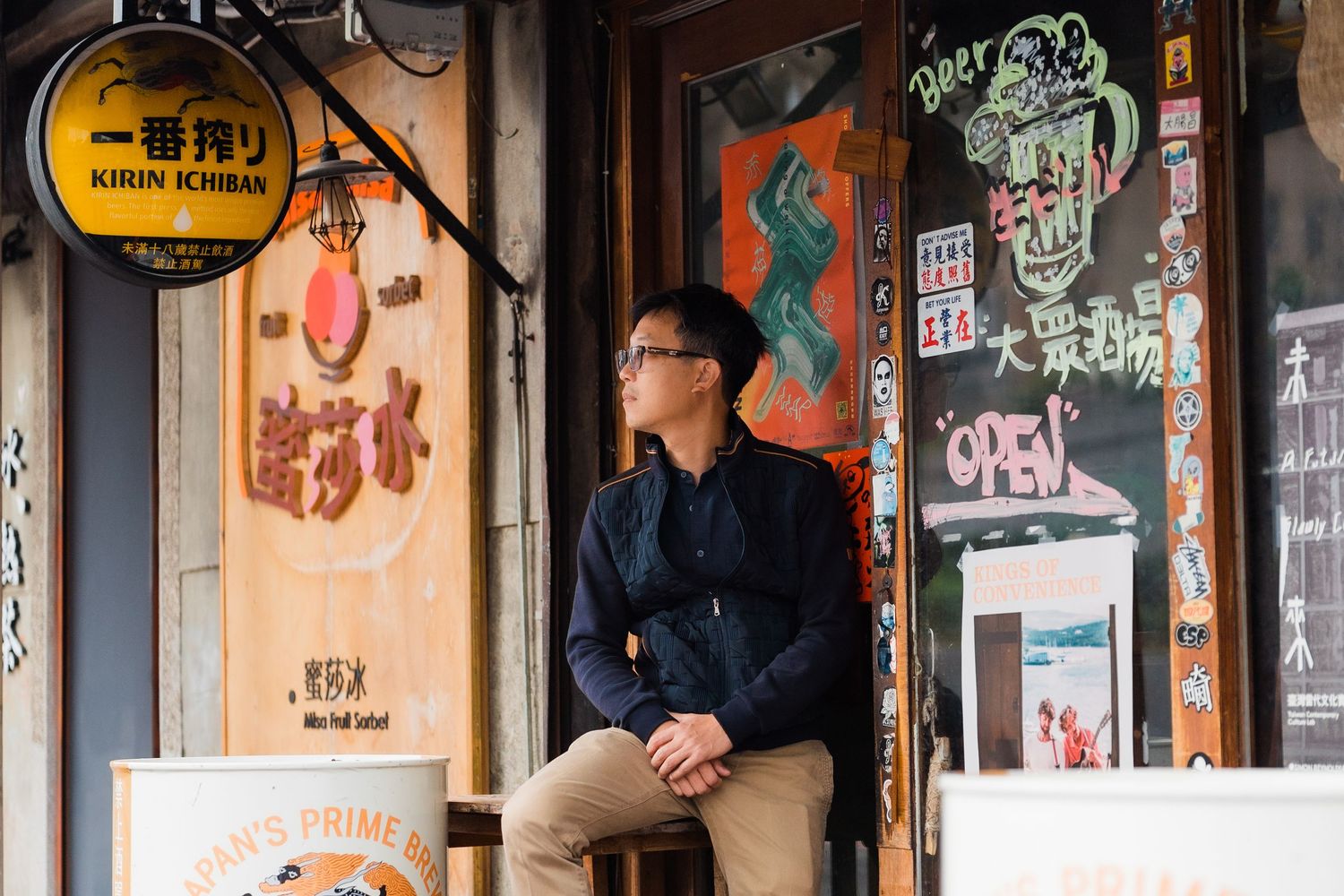 Person posing casually outside an Asian restaurant with Kirin beer signage.