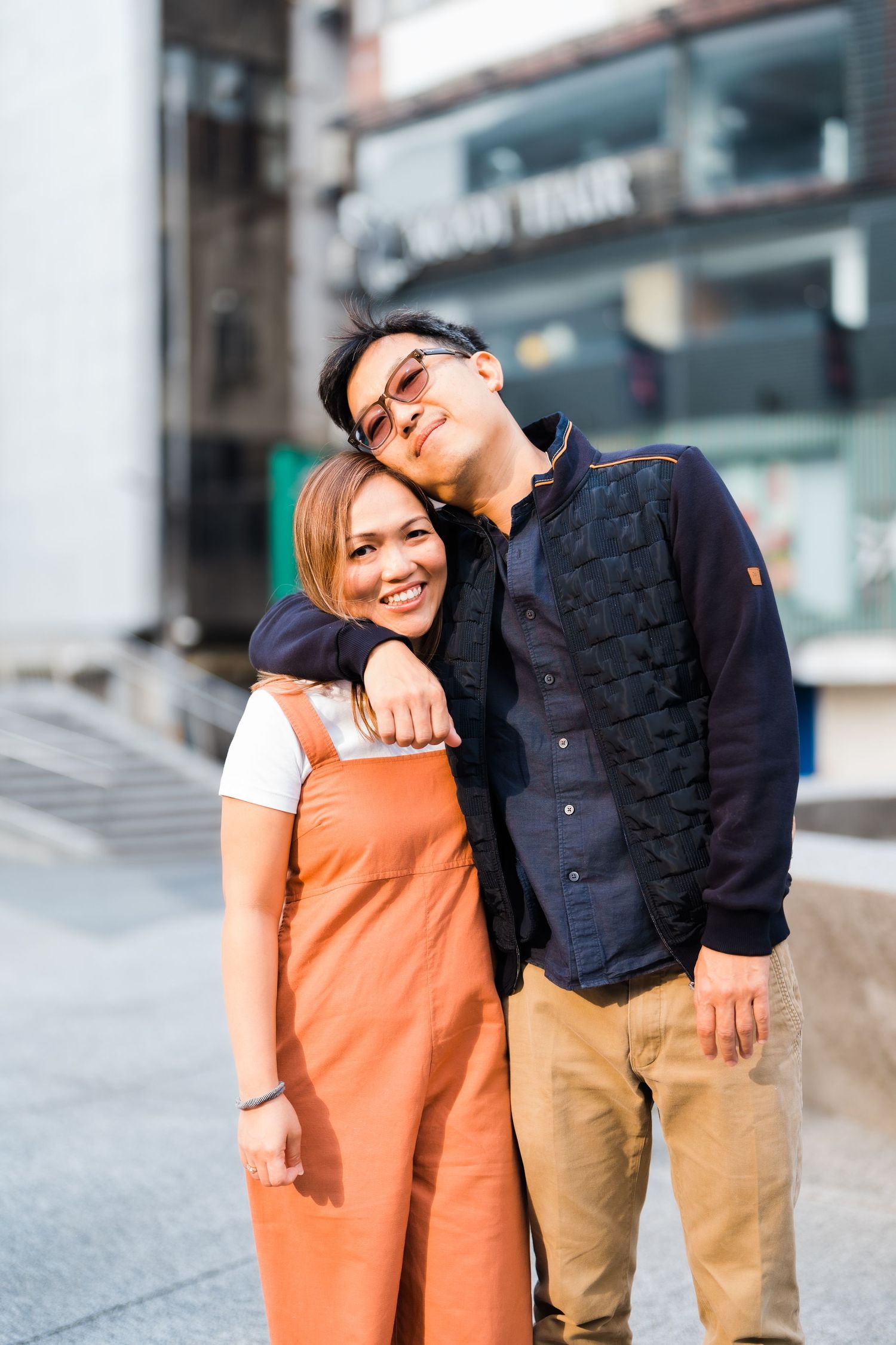 A couple sharing a sweet moment together on a city street.