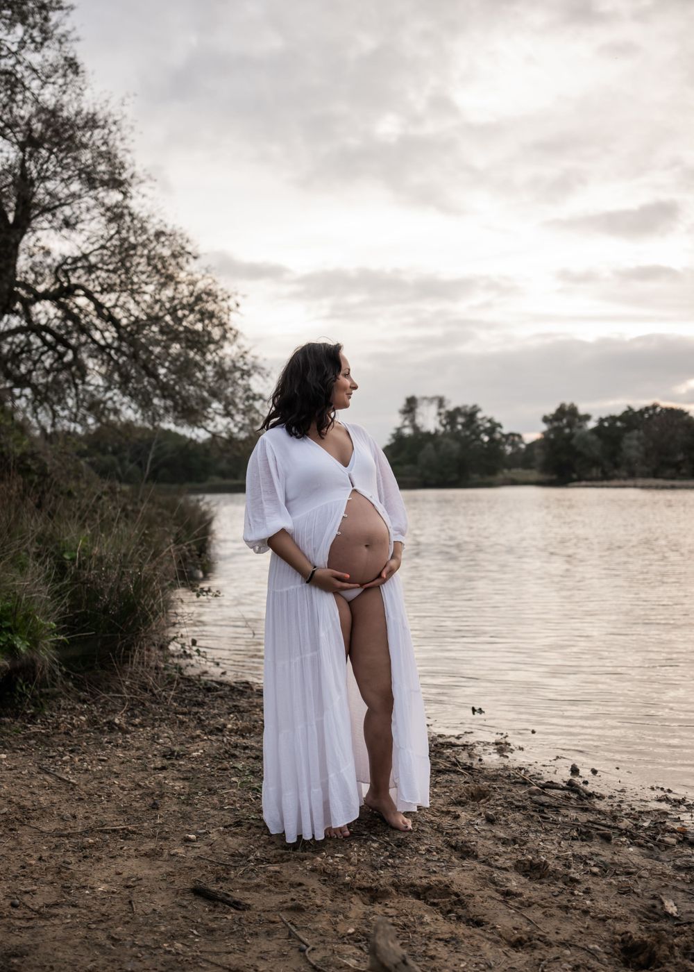 A pregnant mum gazing out at the sunset during an outdoor photography session in London.