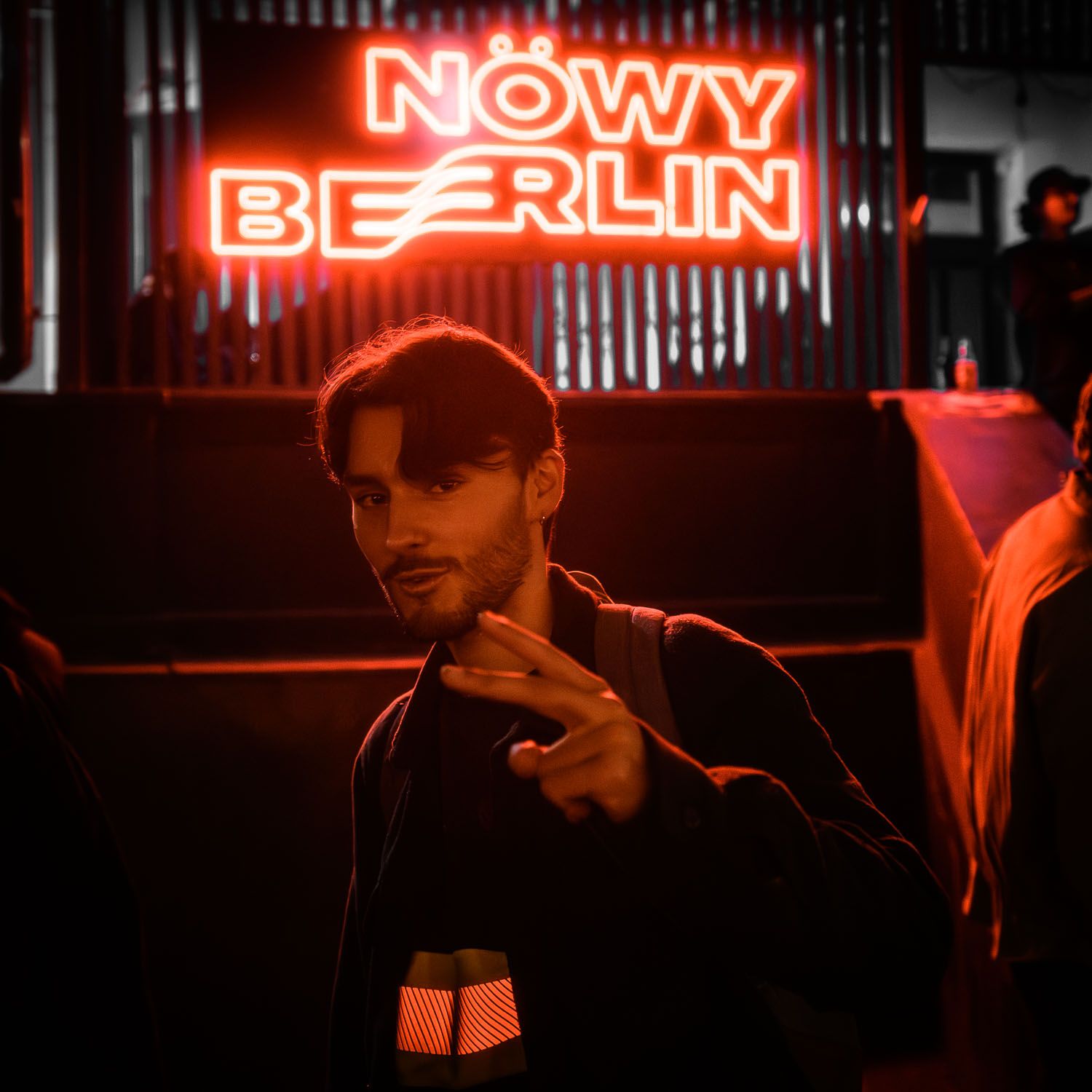 Red neon sign reading 'Nowy Berlin' in a dimly lit nightclub atmosphere.