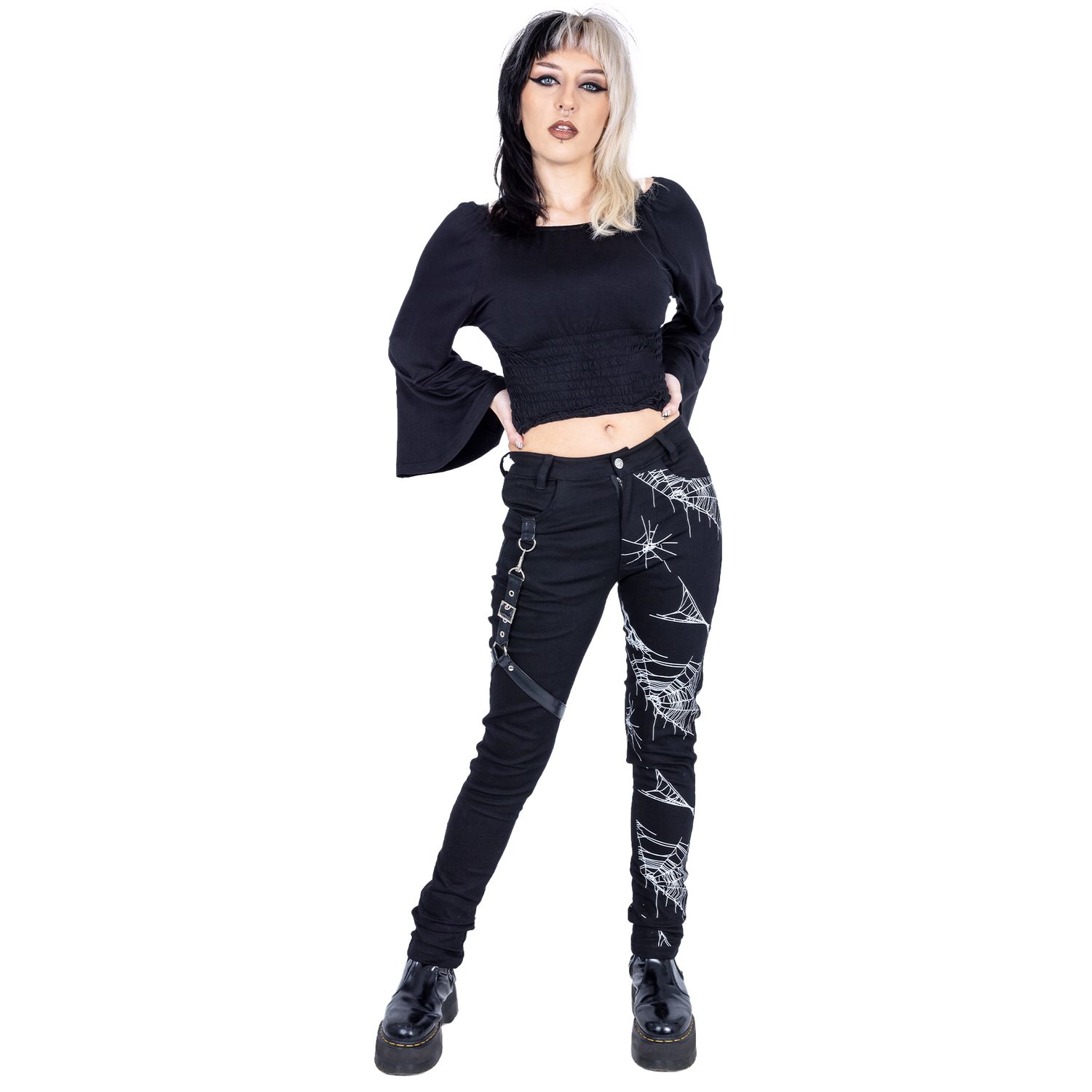Split blonde and black haired femme model wearing gothic alternative styled clothing for small fashion brand in a studio