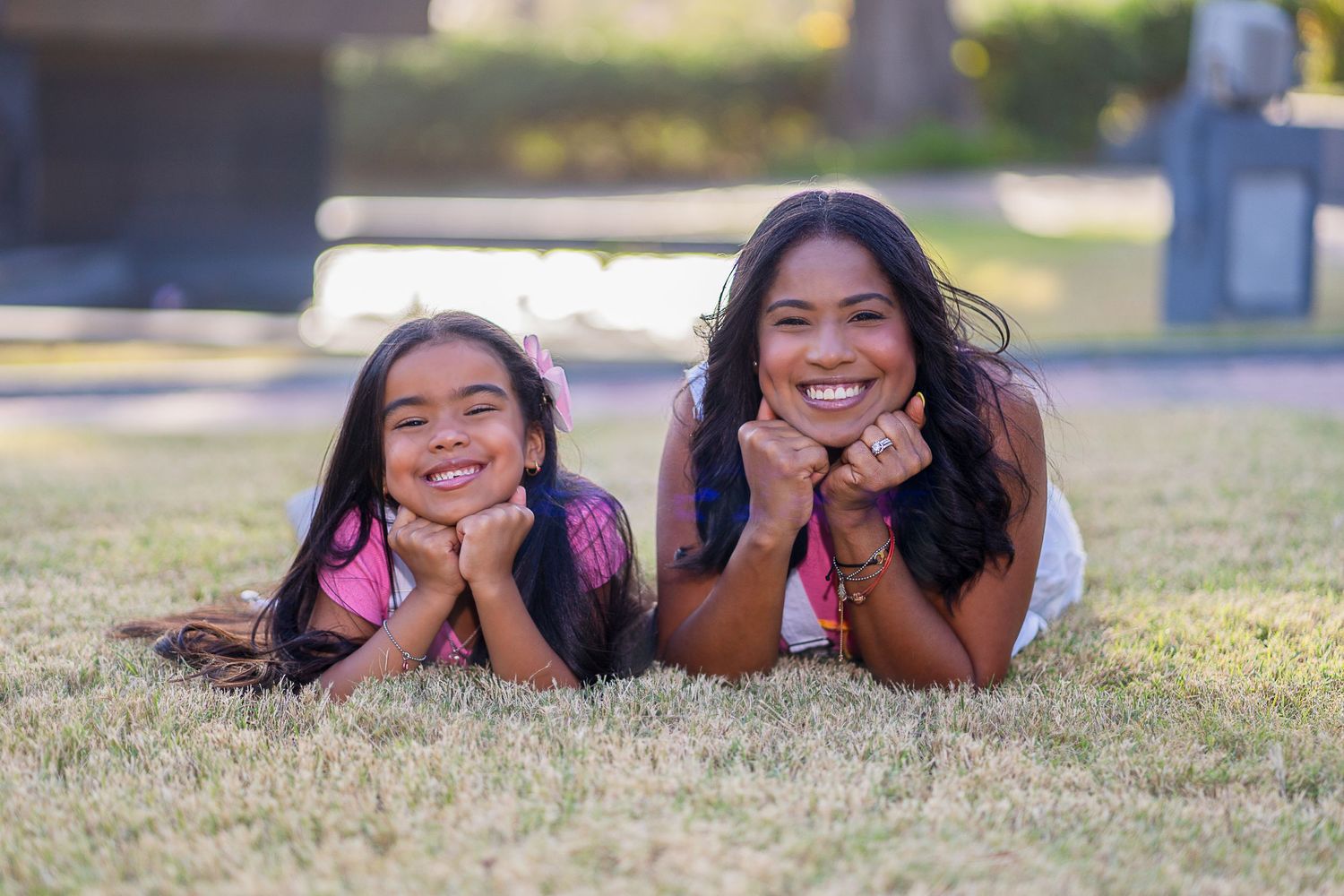 Joyful portrait laying on grass lawn with matching poses.